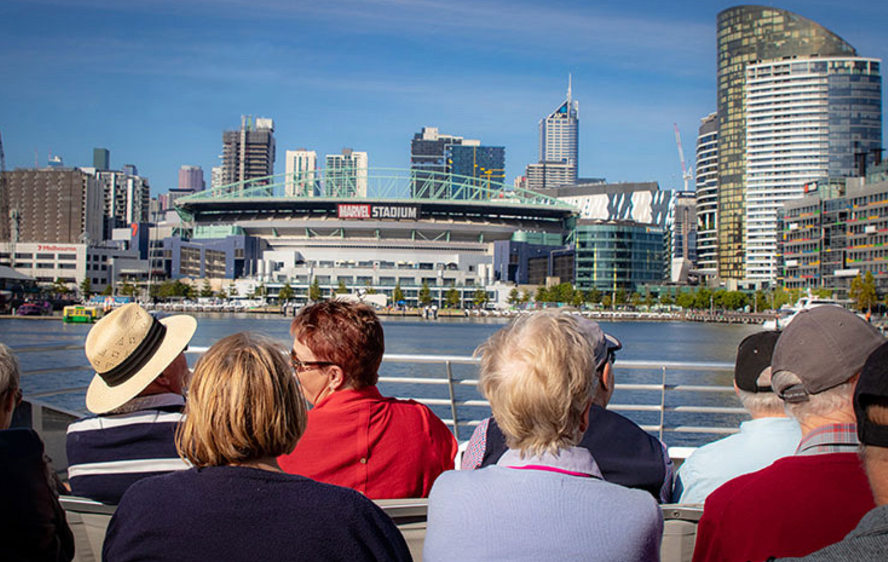 Passengers look over the Yarra River across to Marvel Stadium on Docklands Discovery Cruises